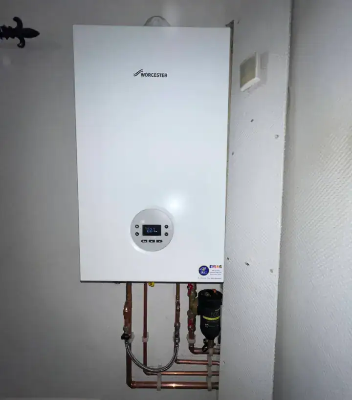 Worcester boiler mounted on a wall with visible pipes and control panel in a domestic setting.