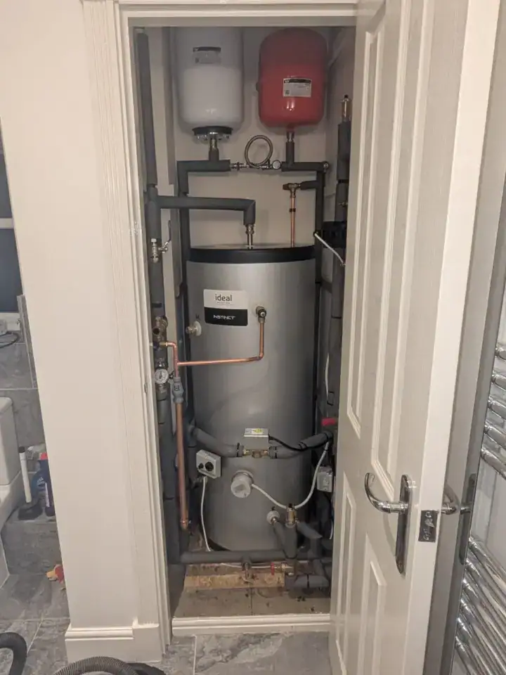 Compact boiler and heating system with expansion tanks in a small utility cupboard.